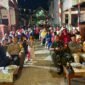 Berbagai lapisan masyarakat tumpah ruah di sepanjang Jalan Toddopuli 22 Blok 35 yang telah didekorasi secara meriah.